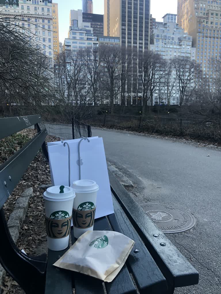 长凳上放着一杯咖啡和一袋咖啡