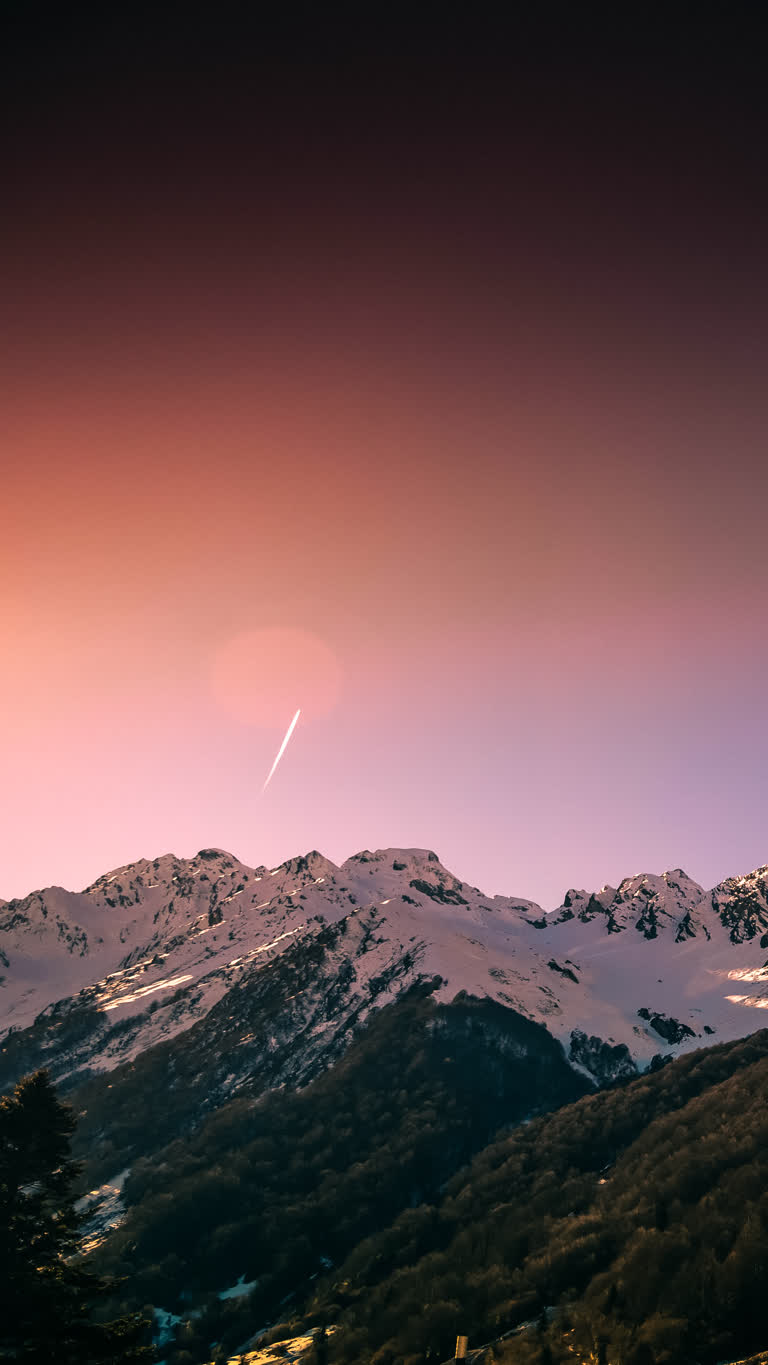 有一架飞机在夕阳时分飞越山